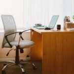 A tranquil modern home office featuring a wooden desk, ergonomic chair, and soft natural light.