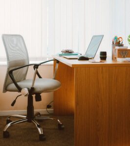 A tranquil modern home office featuring a wooden desk, ergonomic chair, and soft natural light.